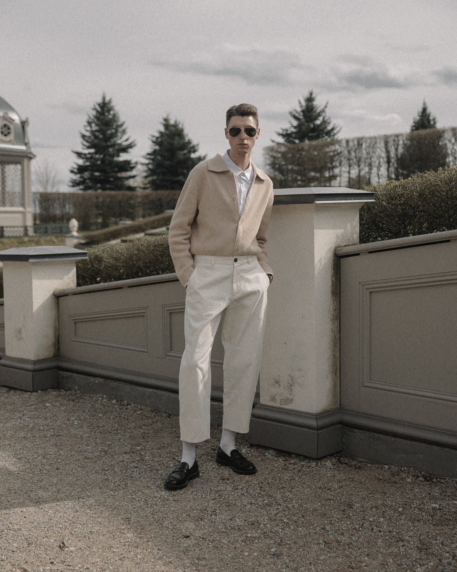 A man in sand linen trousers and a matching knit