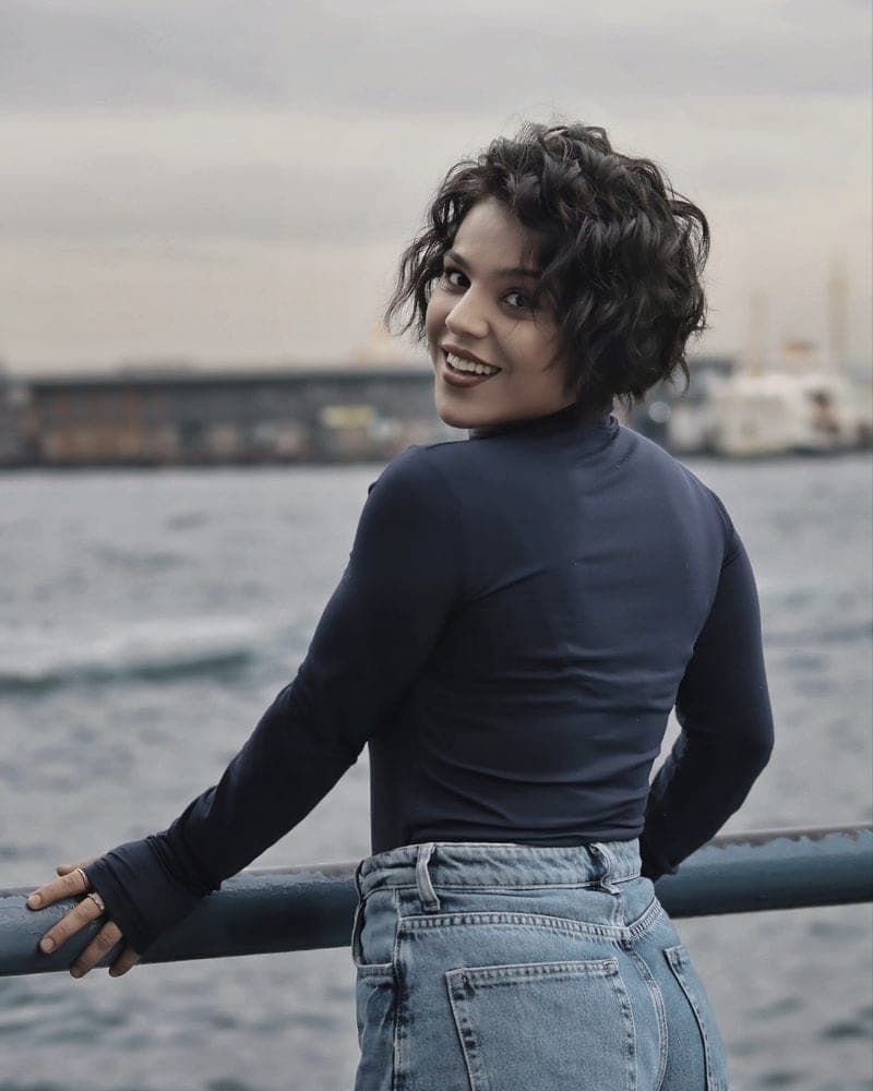 A model in a navy ribbed turtleneck