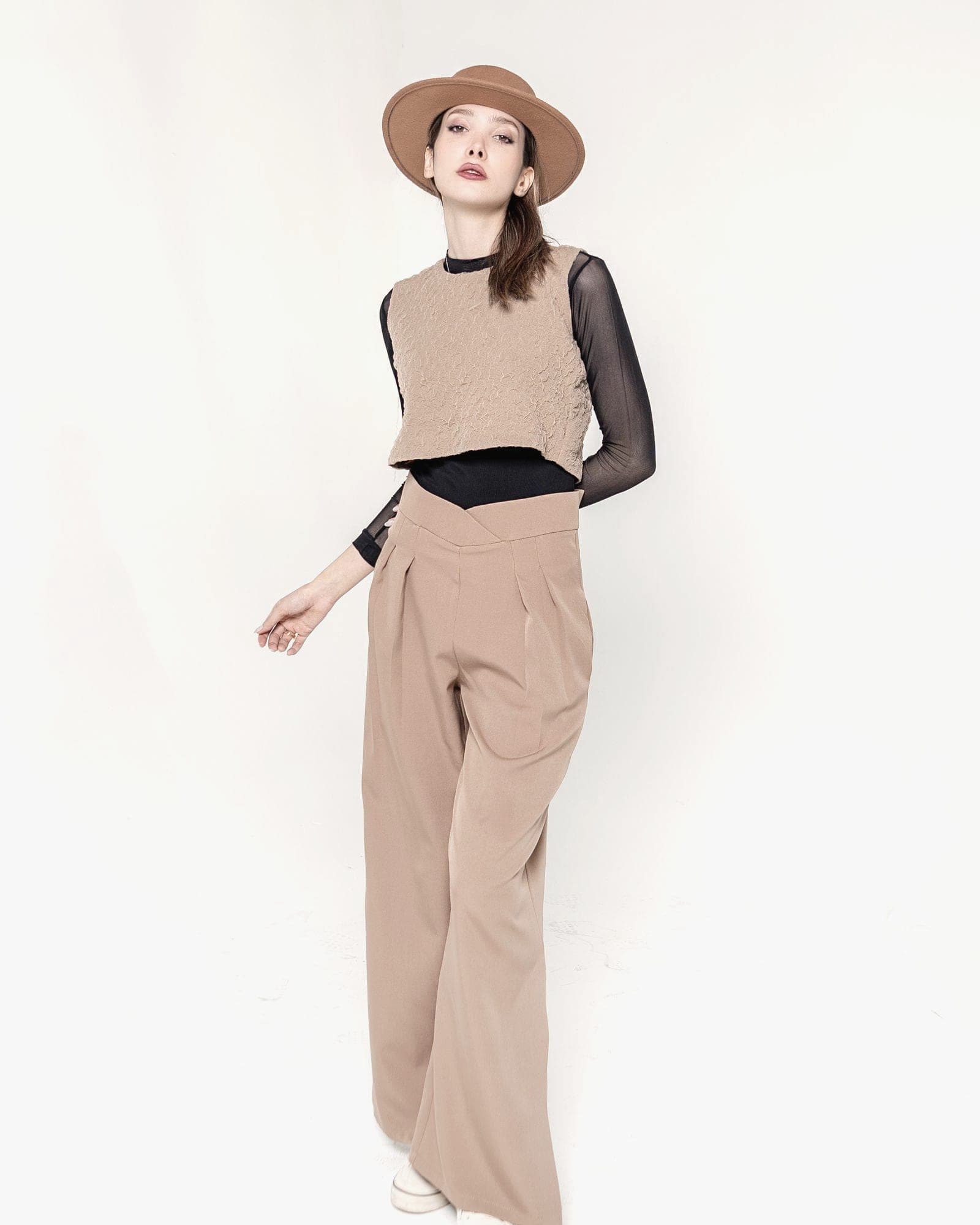 A model in camel tailored trousers